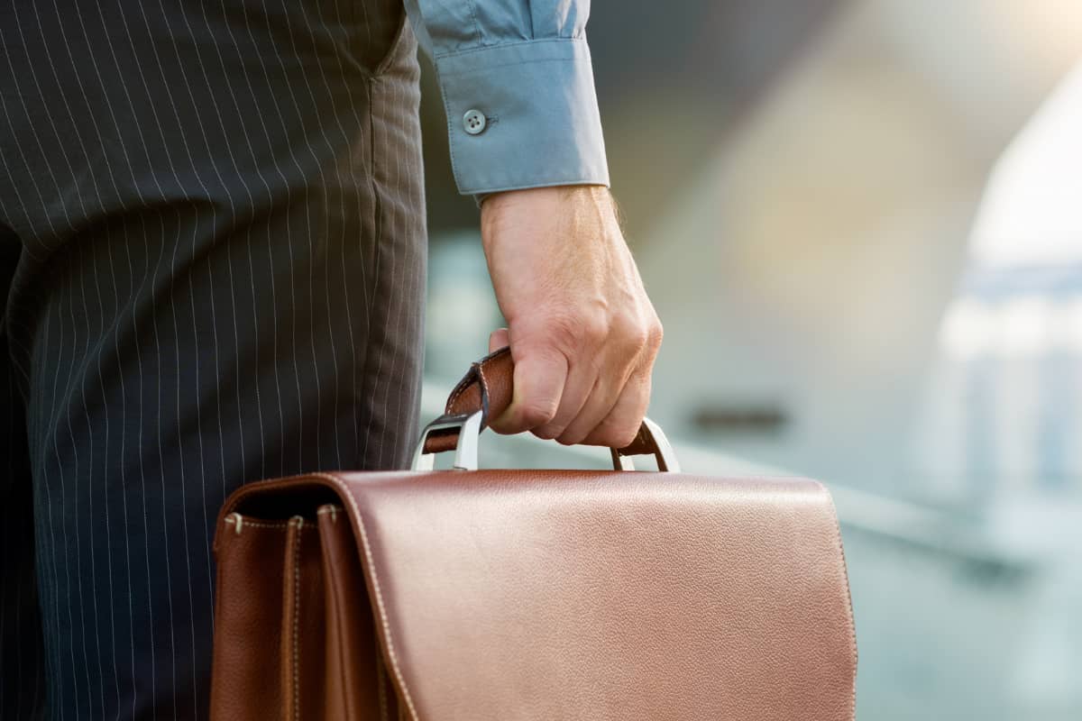 Emprendedor sujetando un maletín en su mano derecha